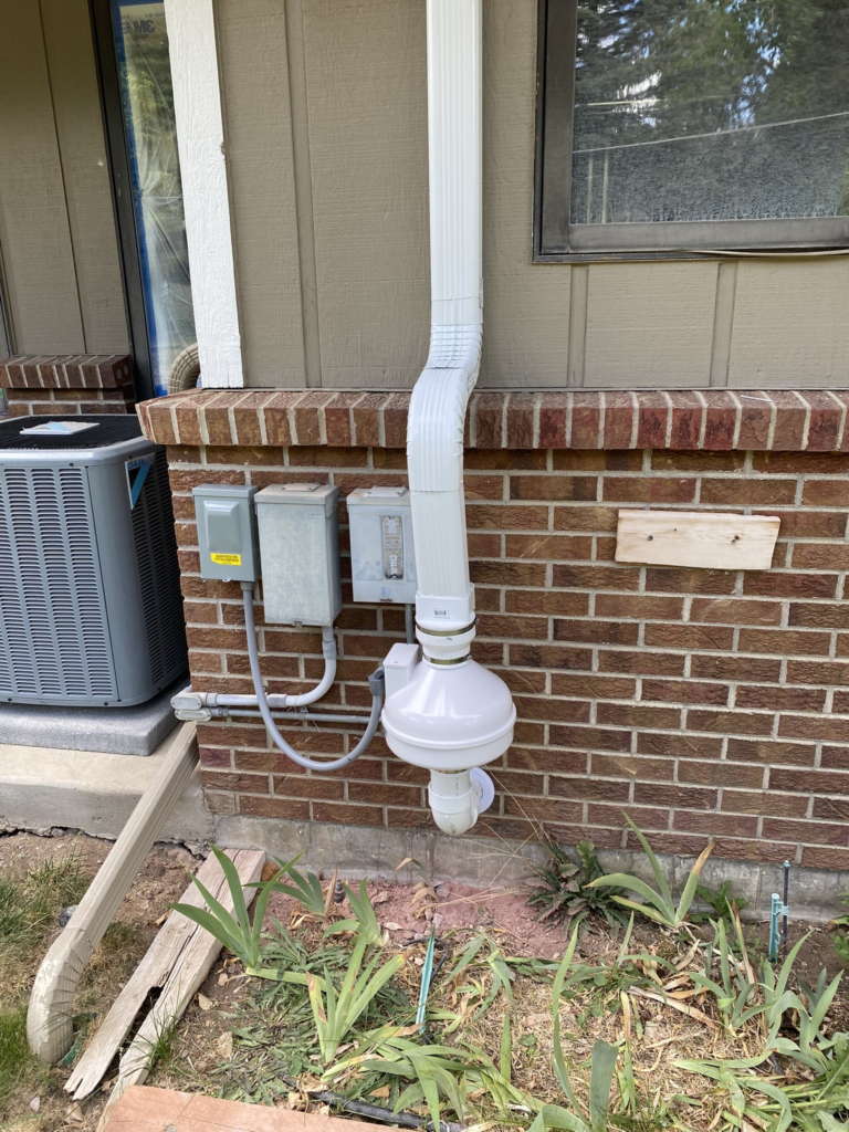 Radon mitigation system with high vacuum fan and color matched downspout