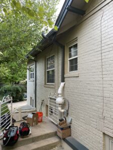 Downspout discharge for radon mitigation system blending seamlessly with home exterior